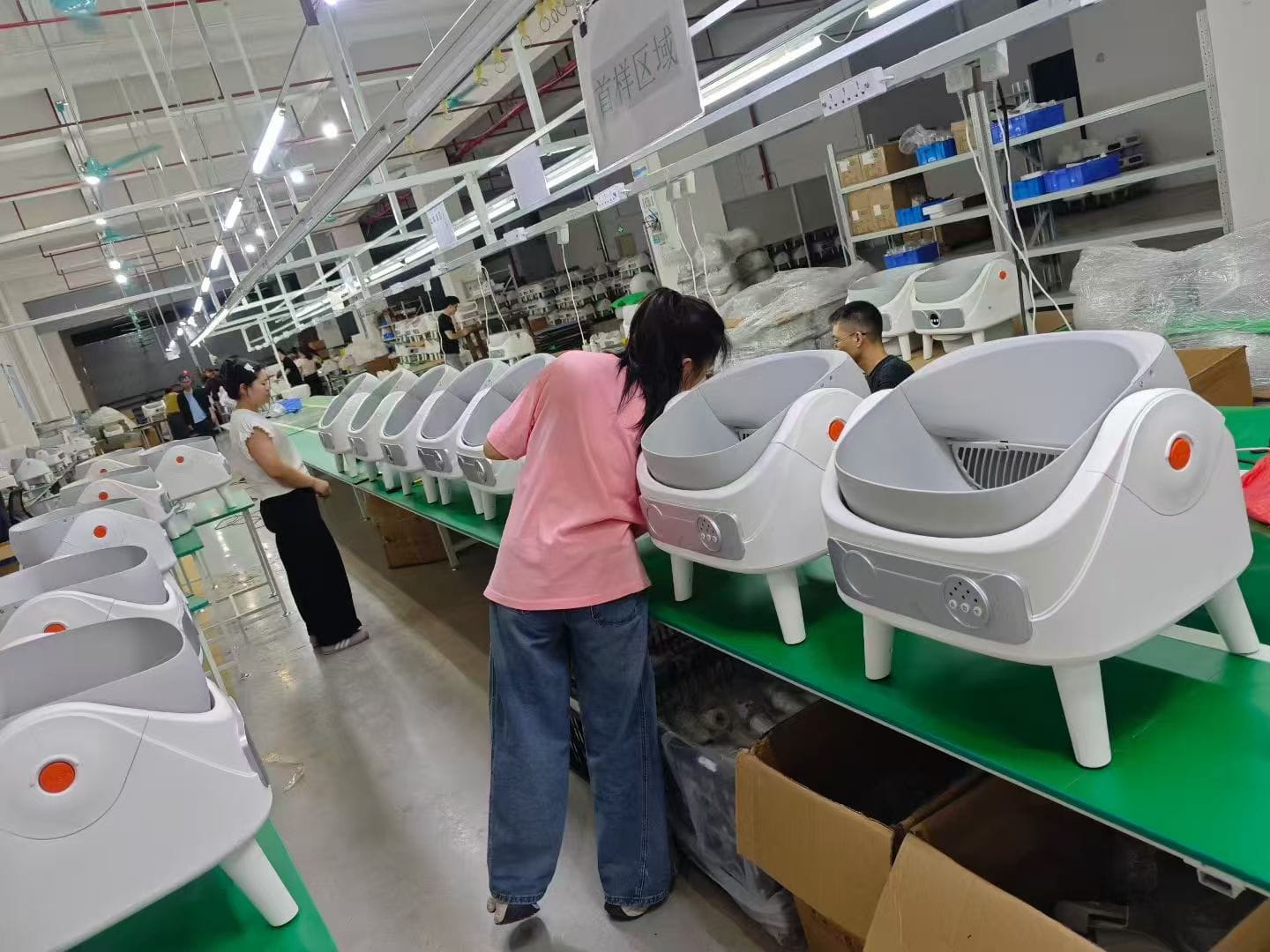 Smart litter box housings undergoing assembly and fit checks on the production line